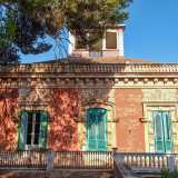 Queste, delimitate da lesene bugnate angolari, presentano tre aperture con persiane verdi...